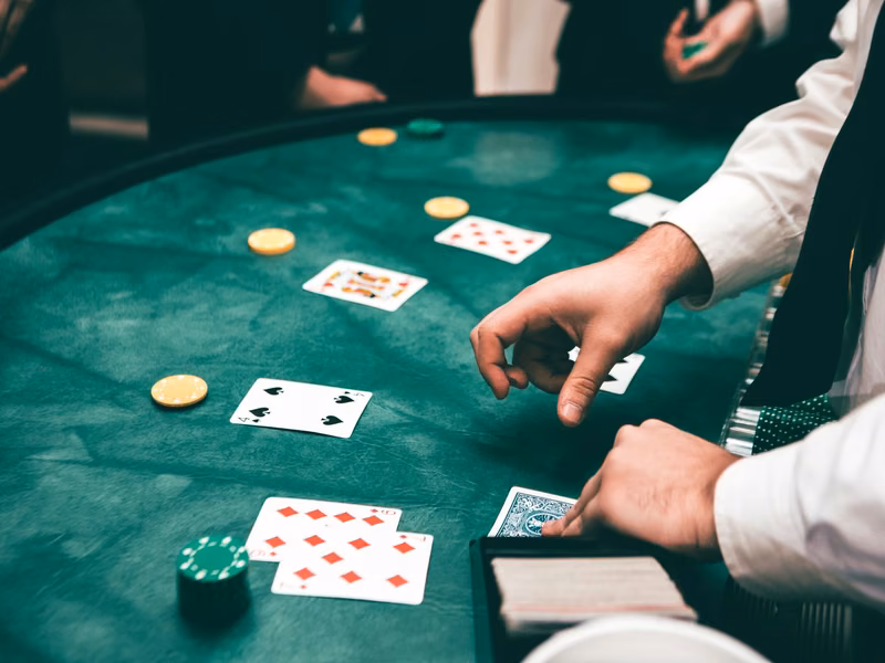 Players' hands placing chips and cards on a green poker table